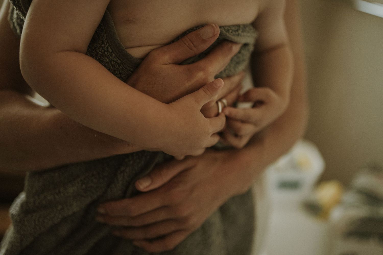 Close-up shot of gentle hands cradling a newborn baby.