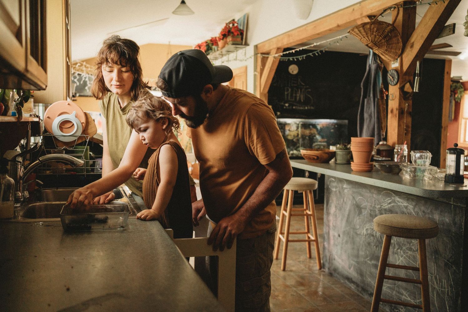 People working together in a rustic kitchen with natural lighting and wooden accents.