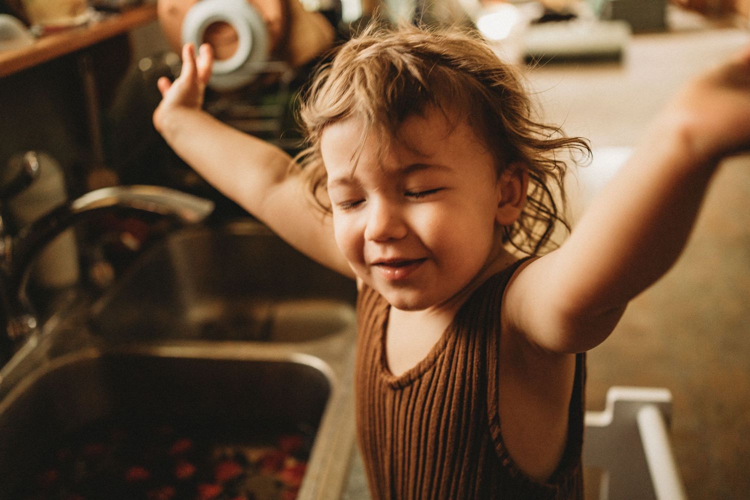 Joyful moment captured in a kitchen with arms raised in celebration.