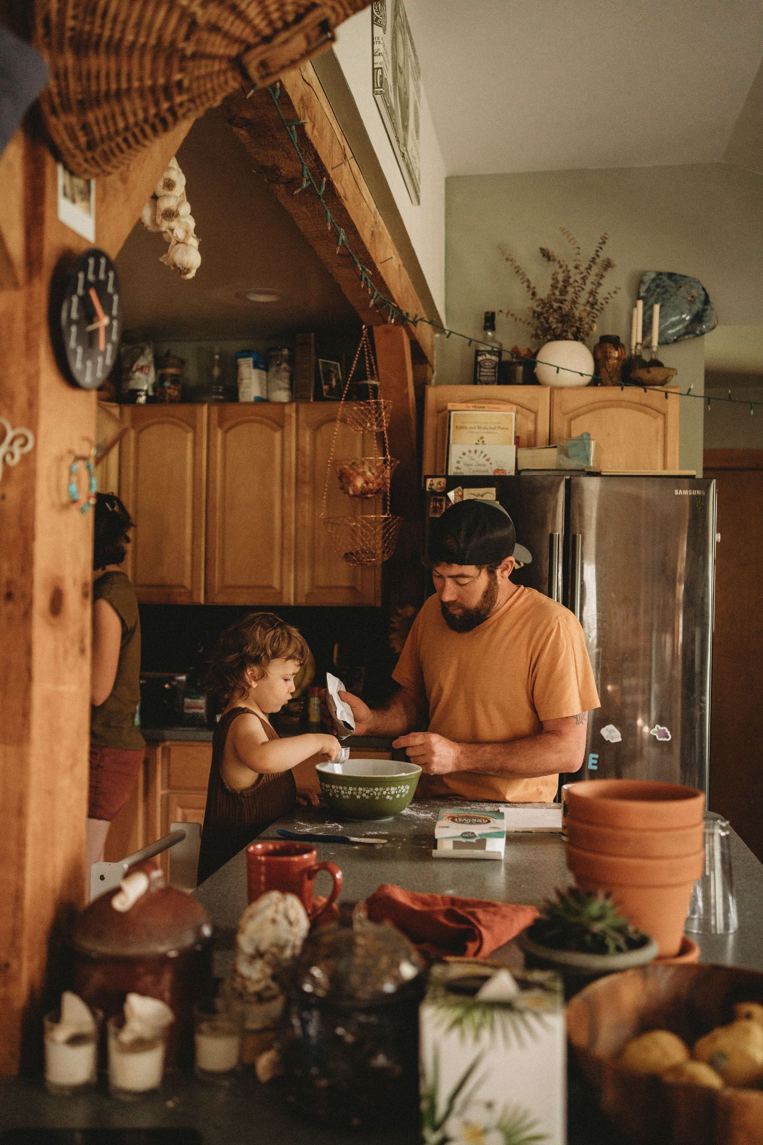 A cozy kitchen scene with wooden accents shows baking ingredients and mixing bowls on the counter.