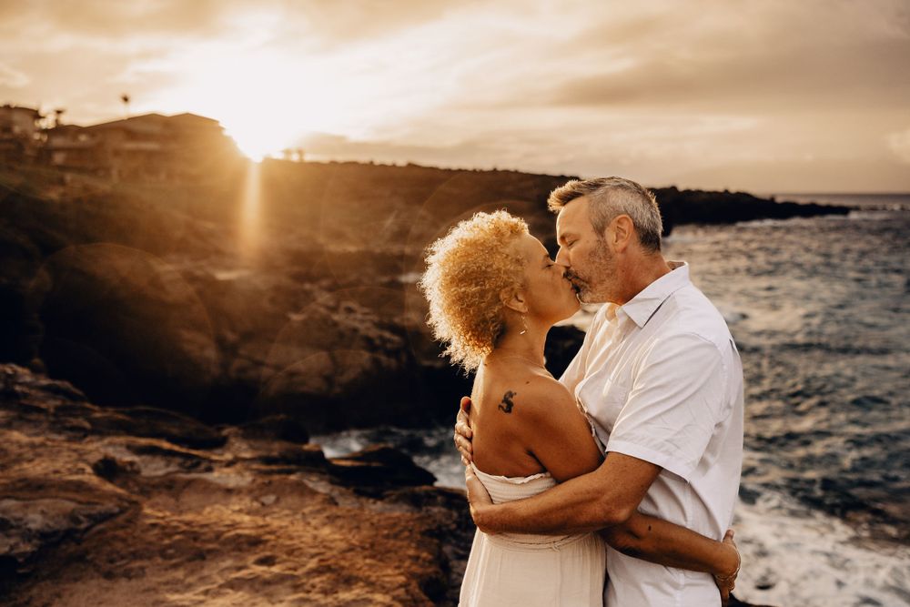 Artistic Candid Maui Engagement Photographer - A couple embraces during a dramatic sunset after getting engaged.