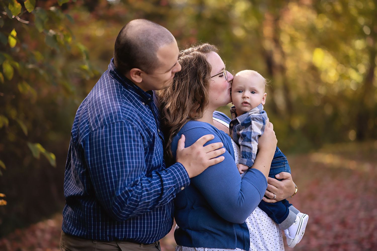 Sweet family moment captured during golden hour in an autumn setting.