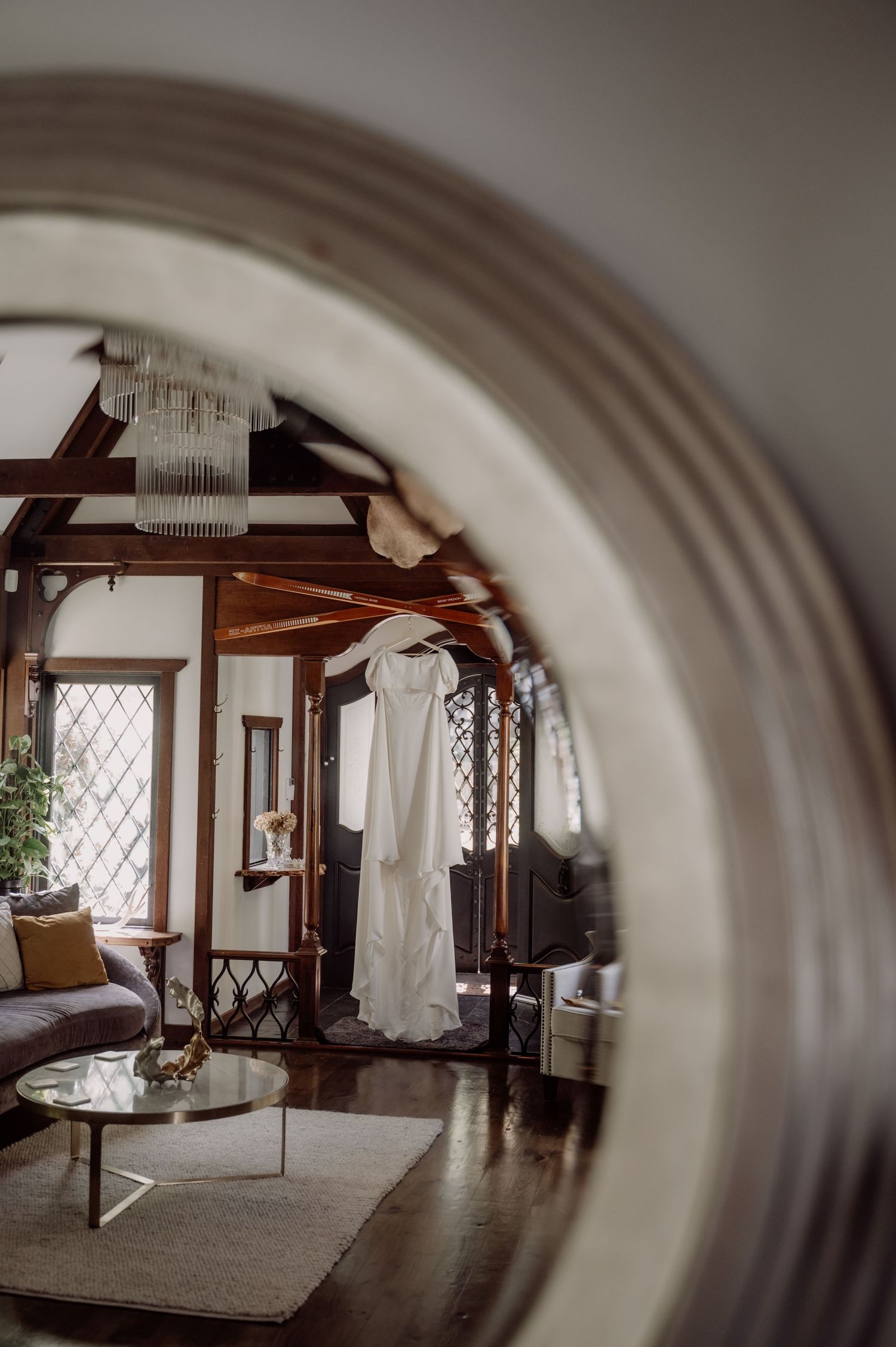 A panoramic view of a rustic interior room with wooden beams, latticed windows and white walls in an old cottage.