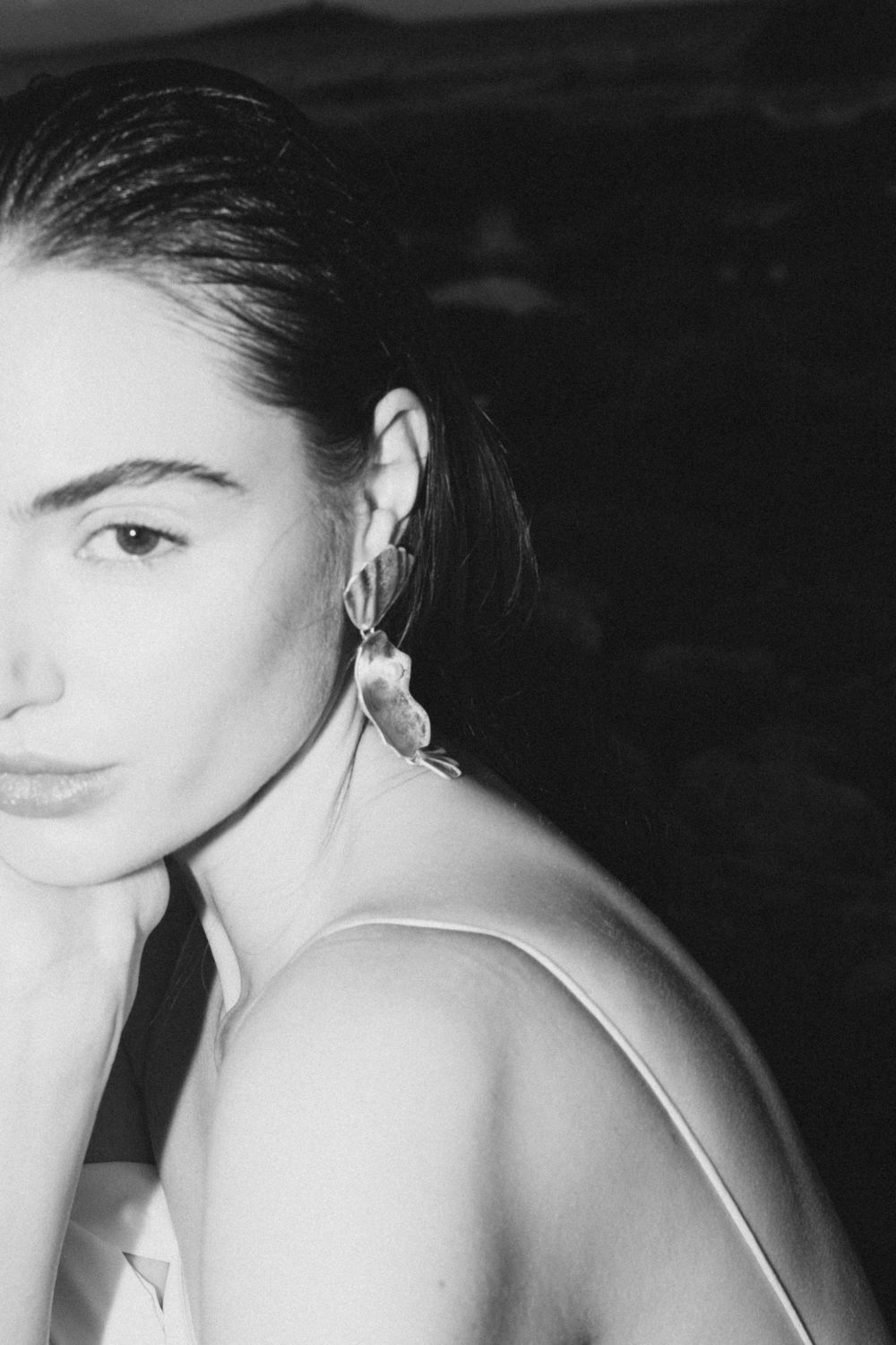 Black and white artistic portrait showing elegant jewelry and minimal styling.
