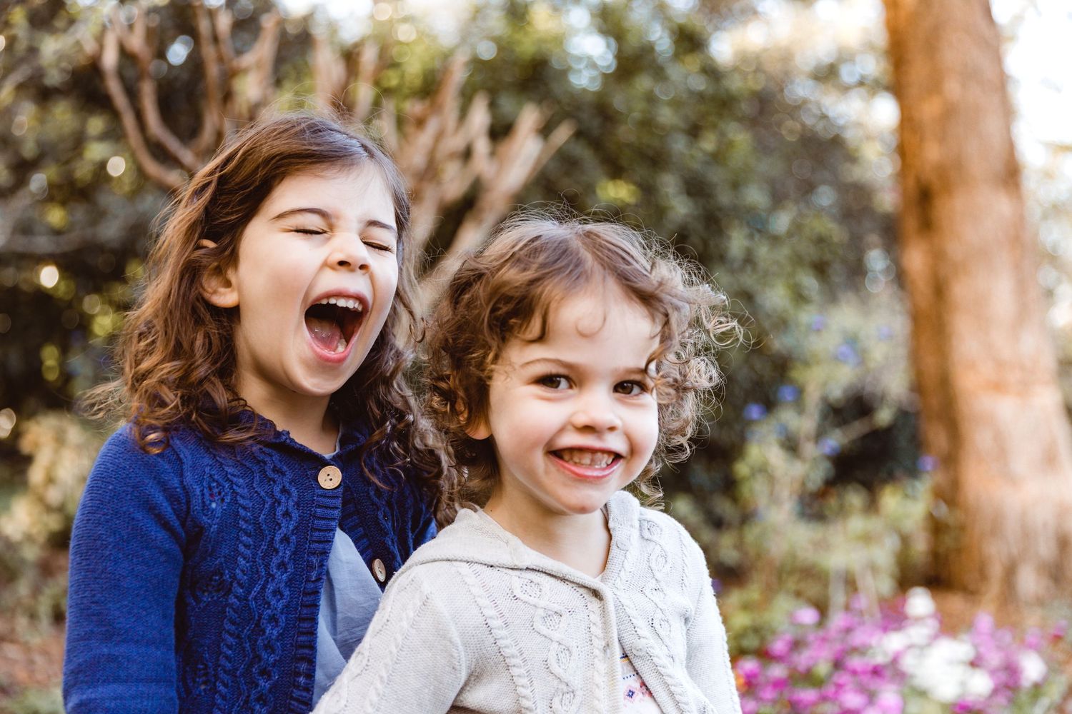 Sisters laughing candidly during a Brisbane family photo shoot