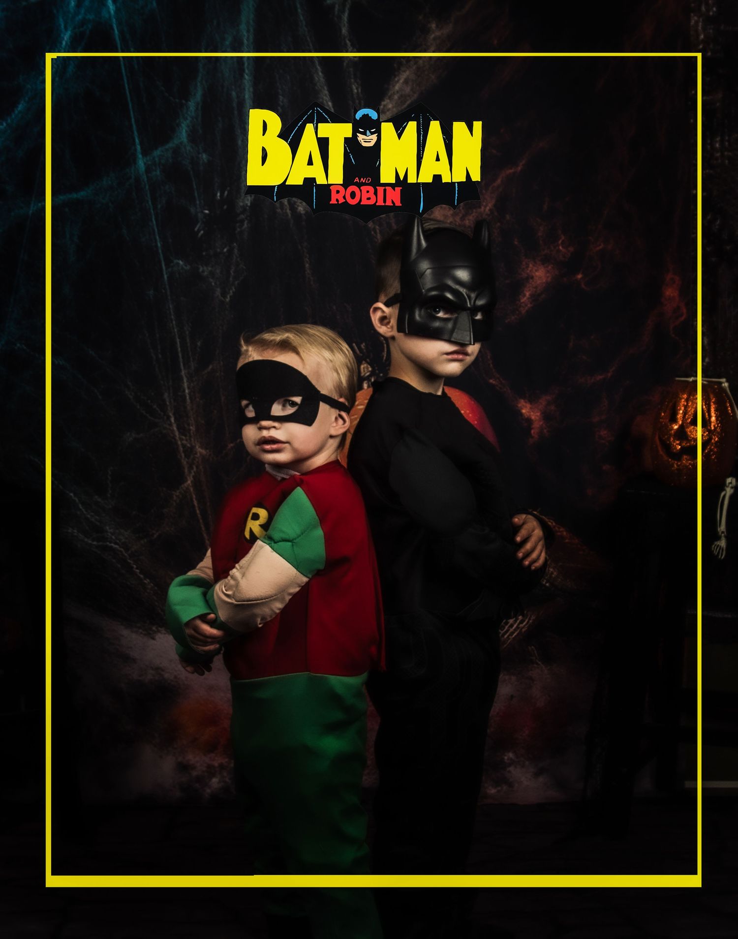 Dramatic portrait of Batman and Robin costumes against a dark Halloween backdrop.