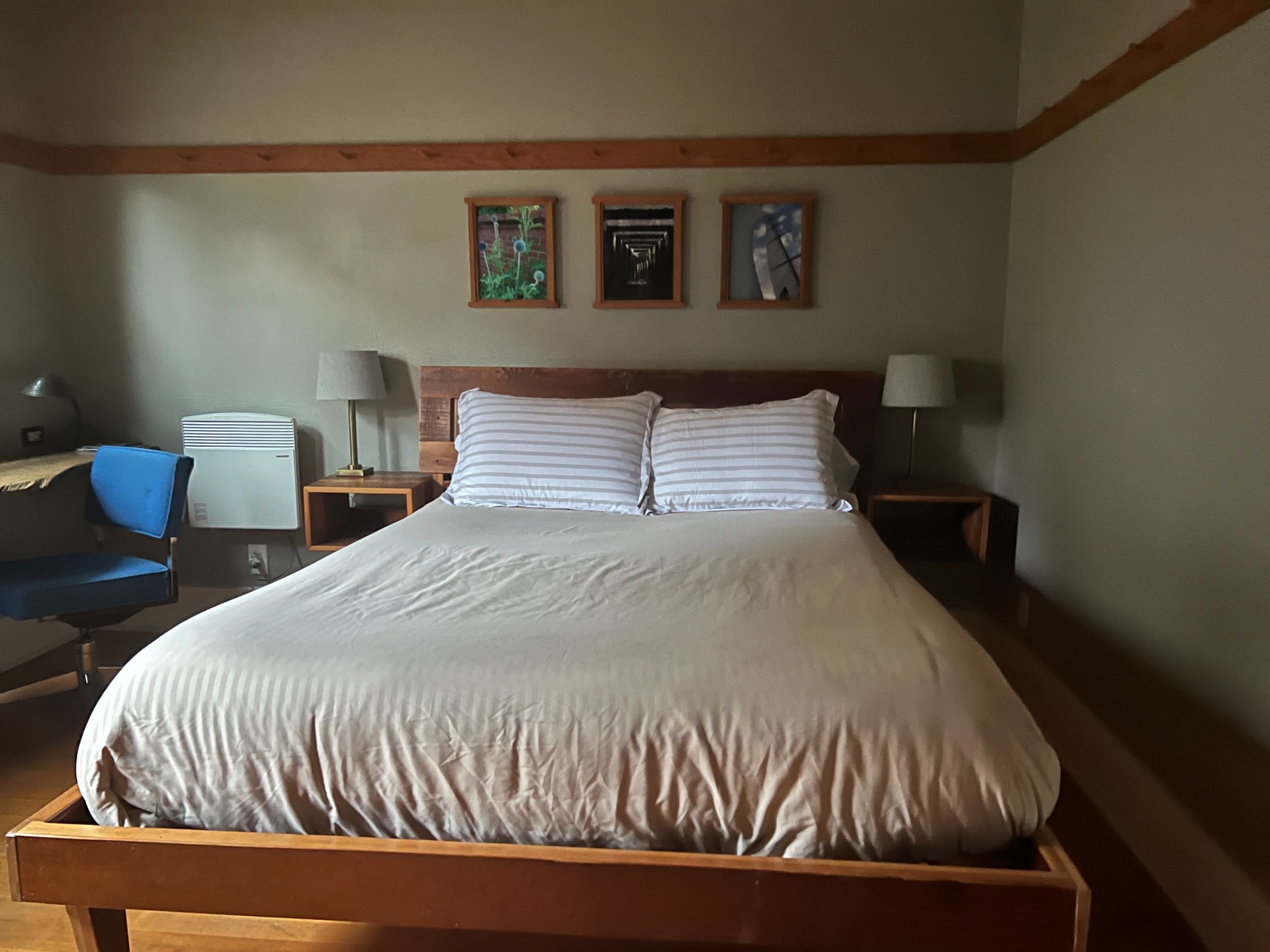 Modern bedroom interior with wooden platform bed and neutral bedding.