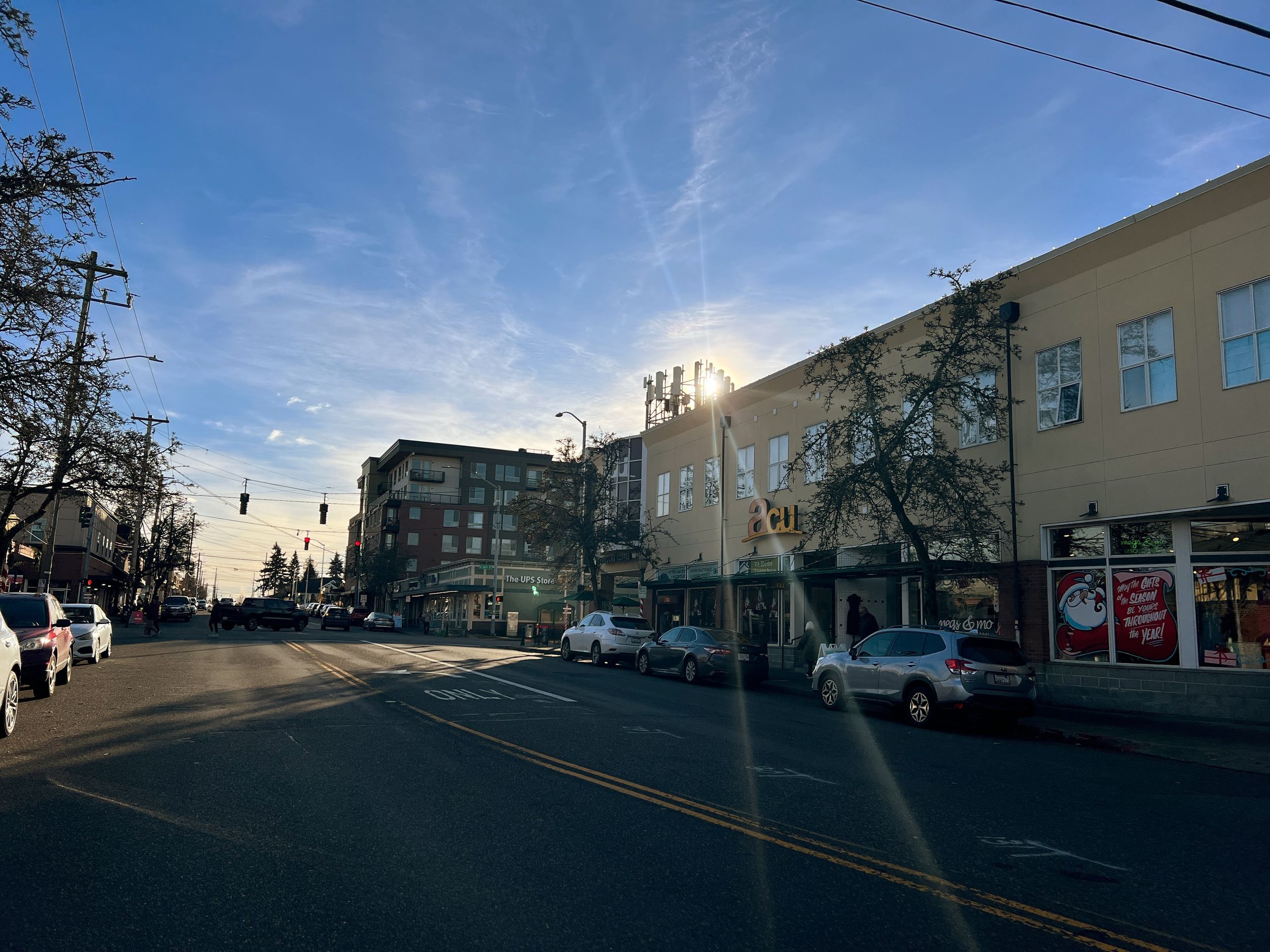Downtown street view with commercial buildings and clear blue sky.