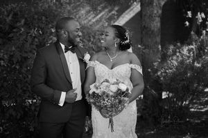Black and white outdoor wedding portrait with elegant bouquet.