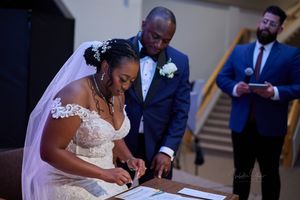Couple signing marriage documents during wedding ceremony.
