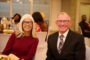 Smiling guests at formal event seated at dining table.