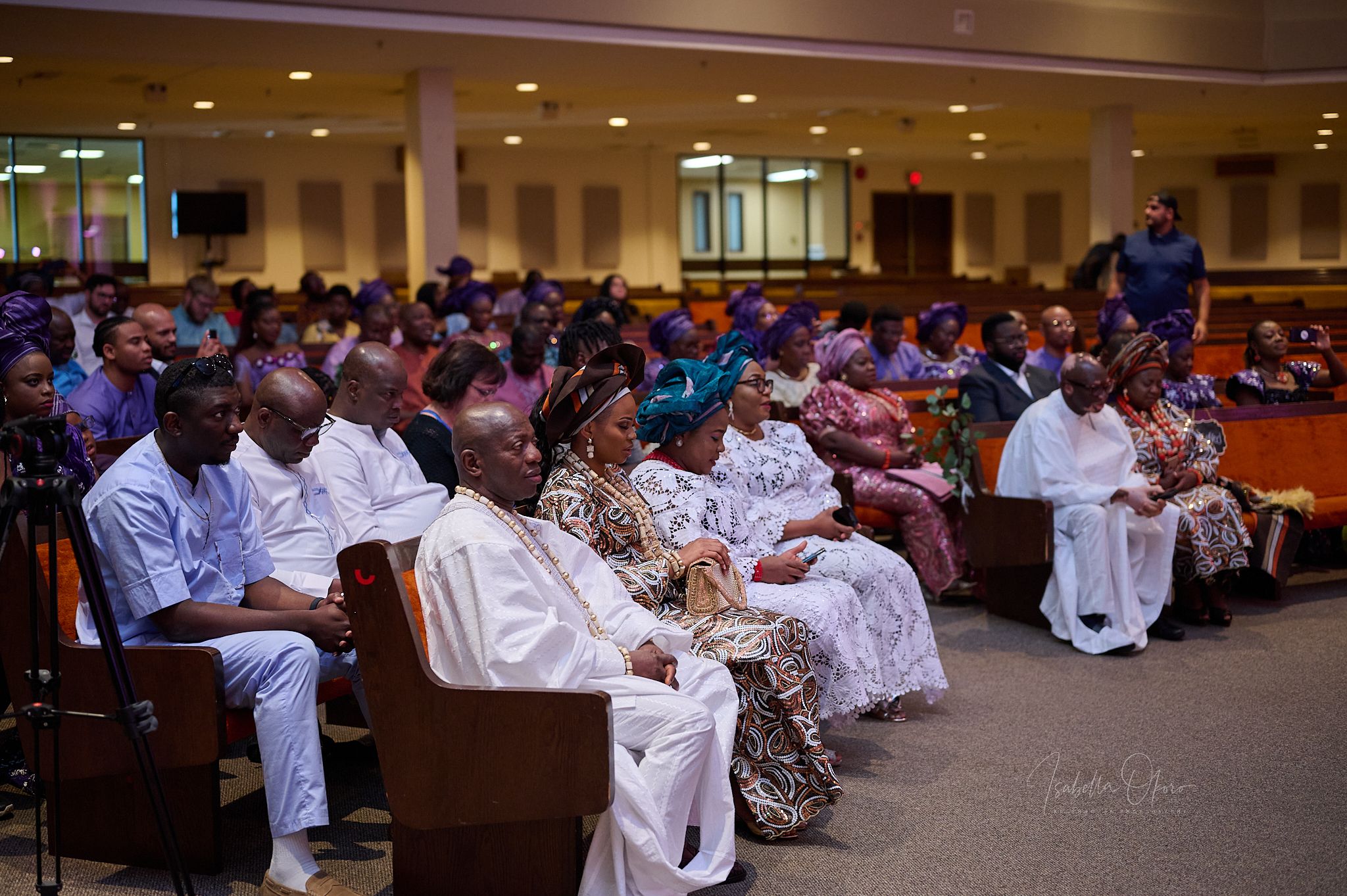Large congregation gathered in church hall wearing traditional white attire.