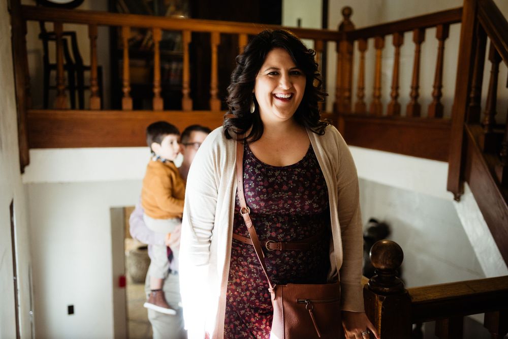 A joyful moment captured at home on a staircase featuring a floral dress and beige cardigan.