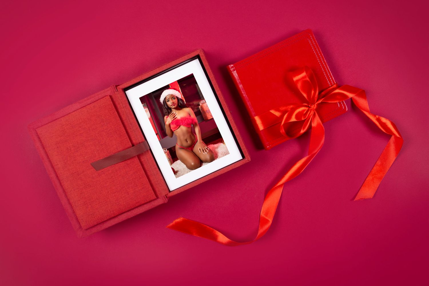 Holiday gift boxes and decorations arranged on vibrant red background with ribbon details.