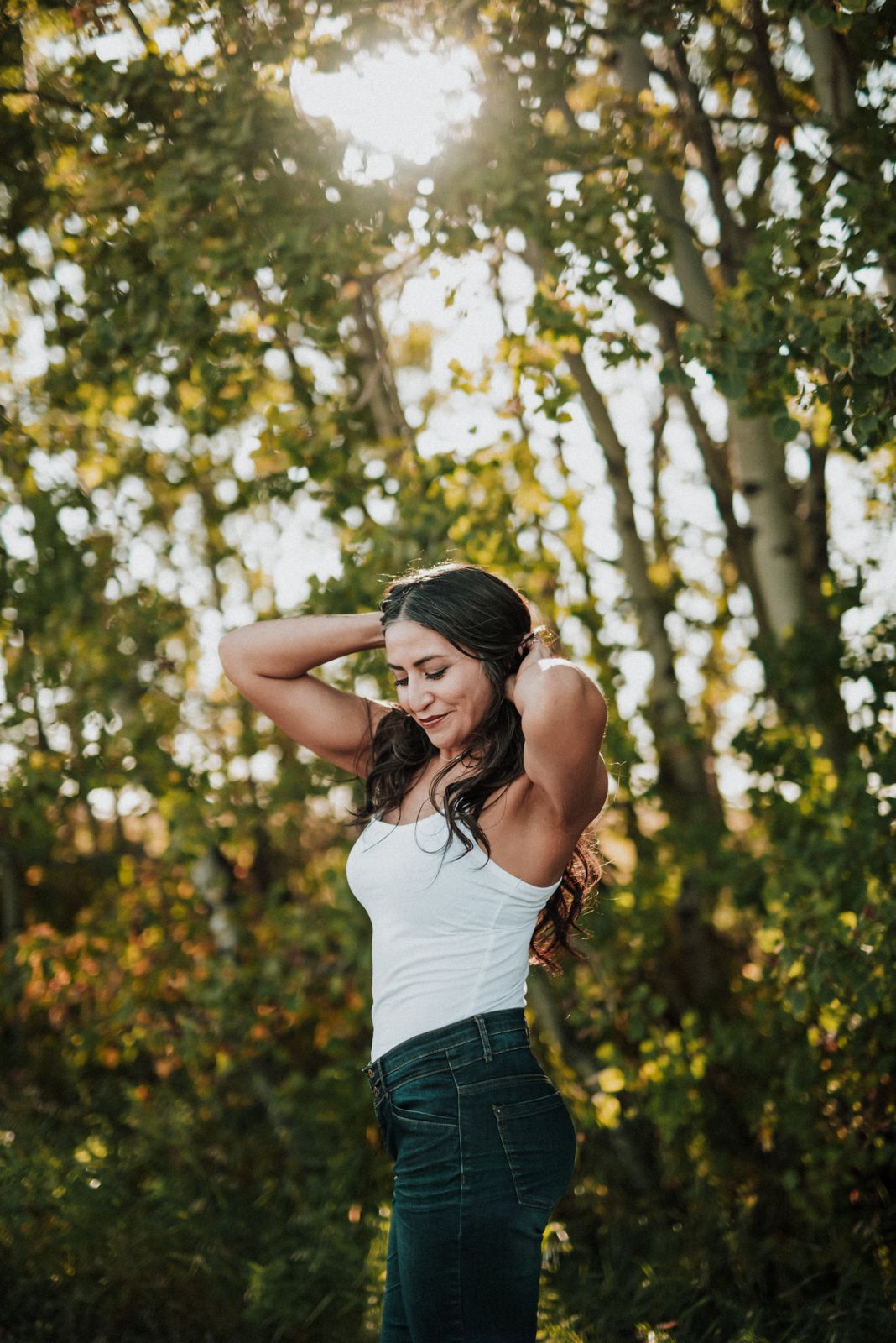 Portrait against autumn forest background with sunlight filtering through trees.