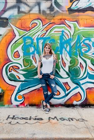 Casual outfit against vibrant graffiti wall featuring turquoise and orange street art.