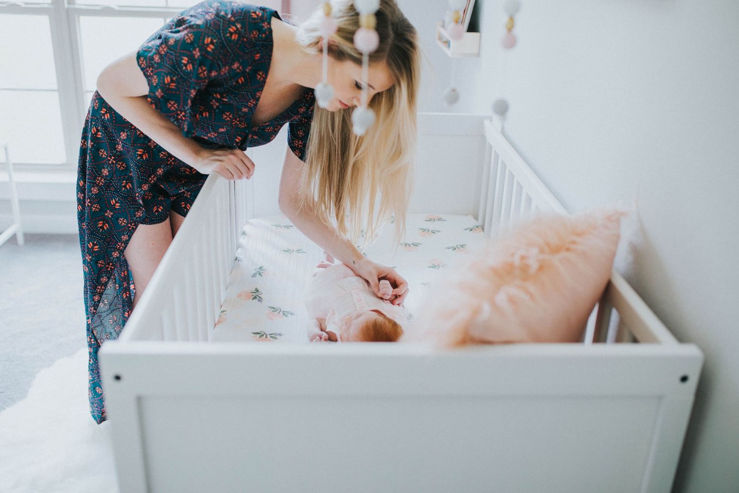 Beautiful red head baby girl laying in white crib