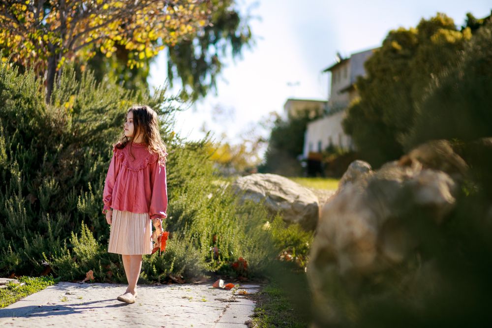 A beautiful picture of a girl walking a path in nature and looking to the sides