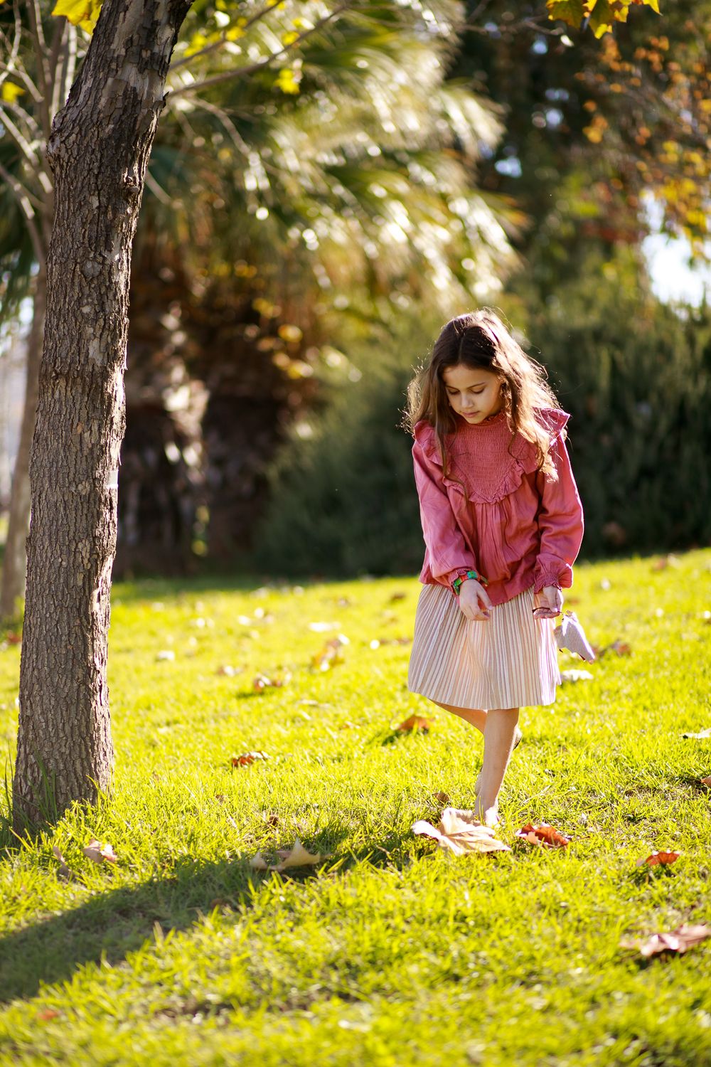 A winter image of a girl hiking in nature and Looking for fallen leaves