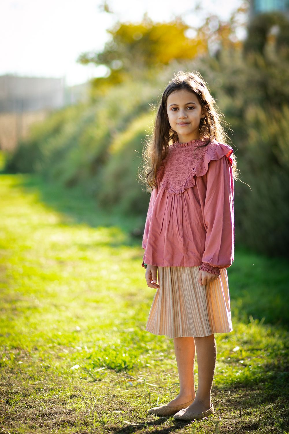 Portrait of a beautiful girl standing in nature and smiling to the camera