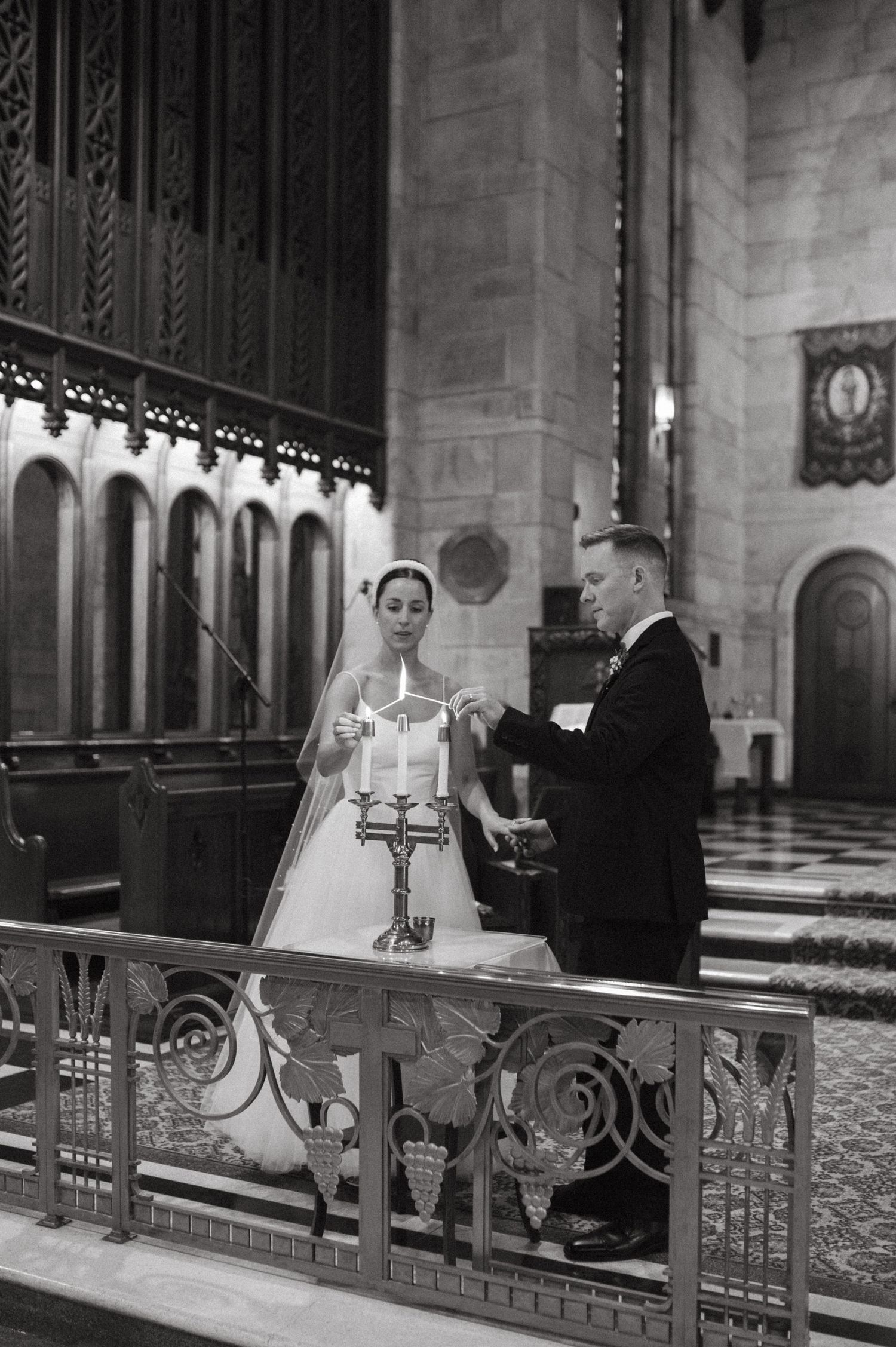 Black and white church ceremony photo with ornate altar details and architecture.
