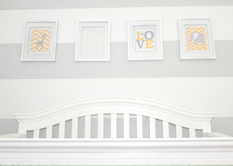 Neutral nursery wall decor featuring white and gold framed prints with chevron and love designs.