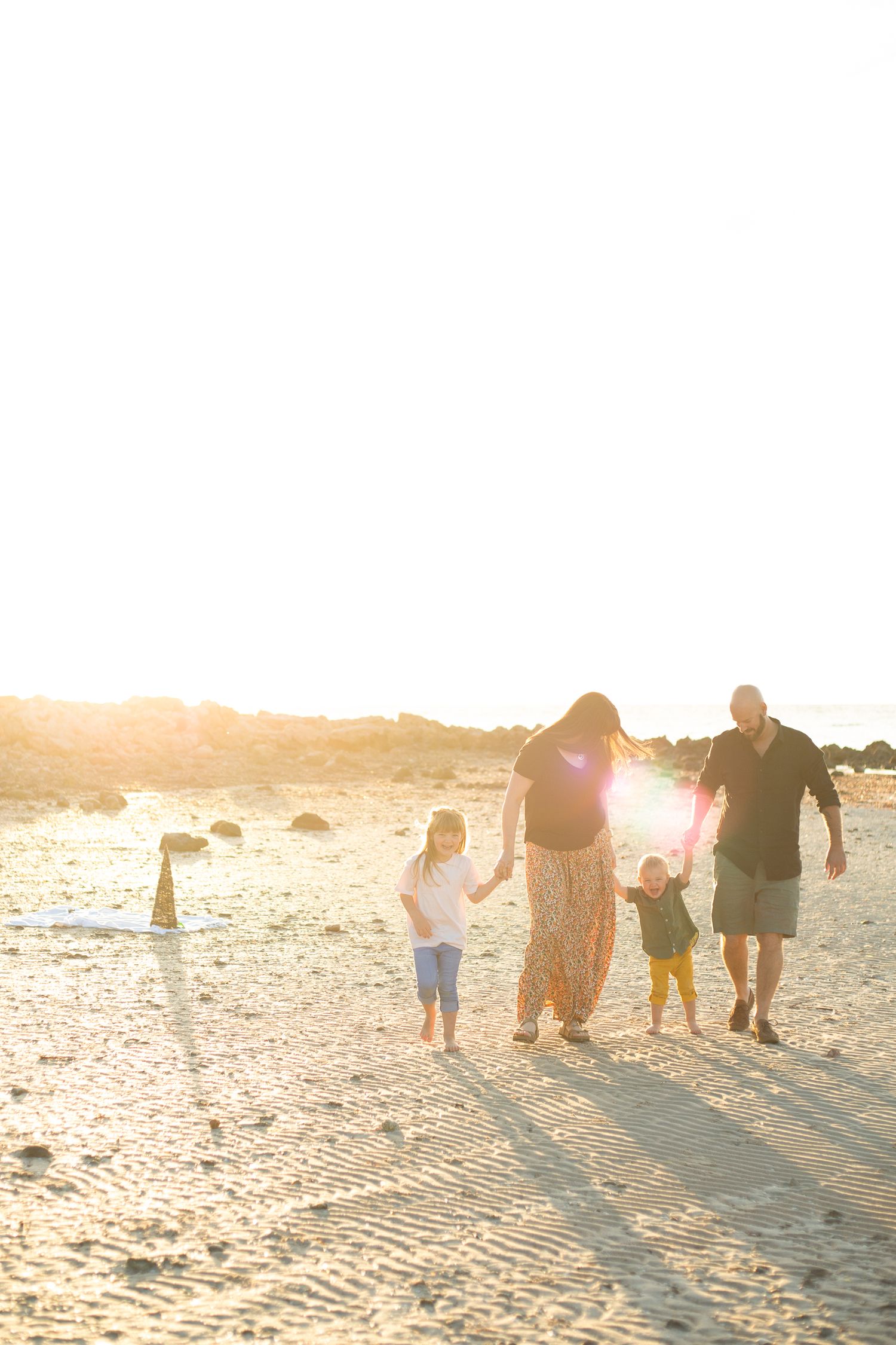 Bianca and family holding hands walking together through the beach