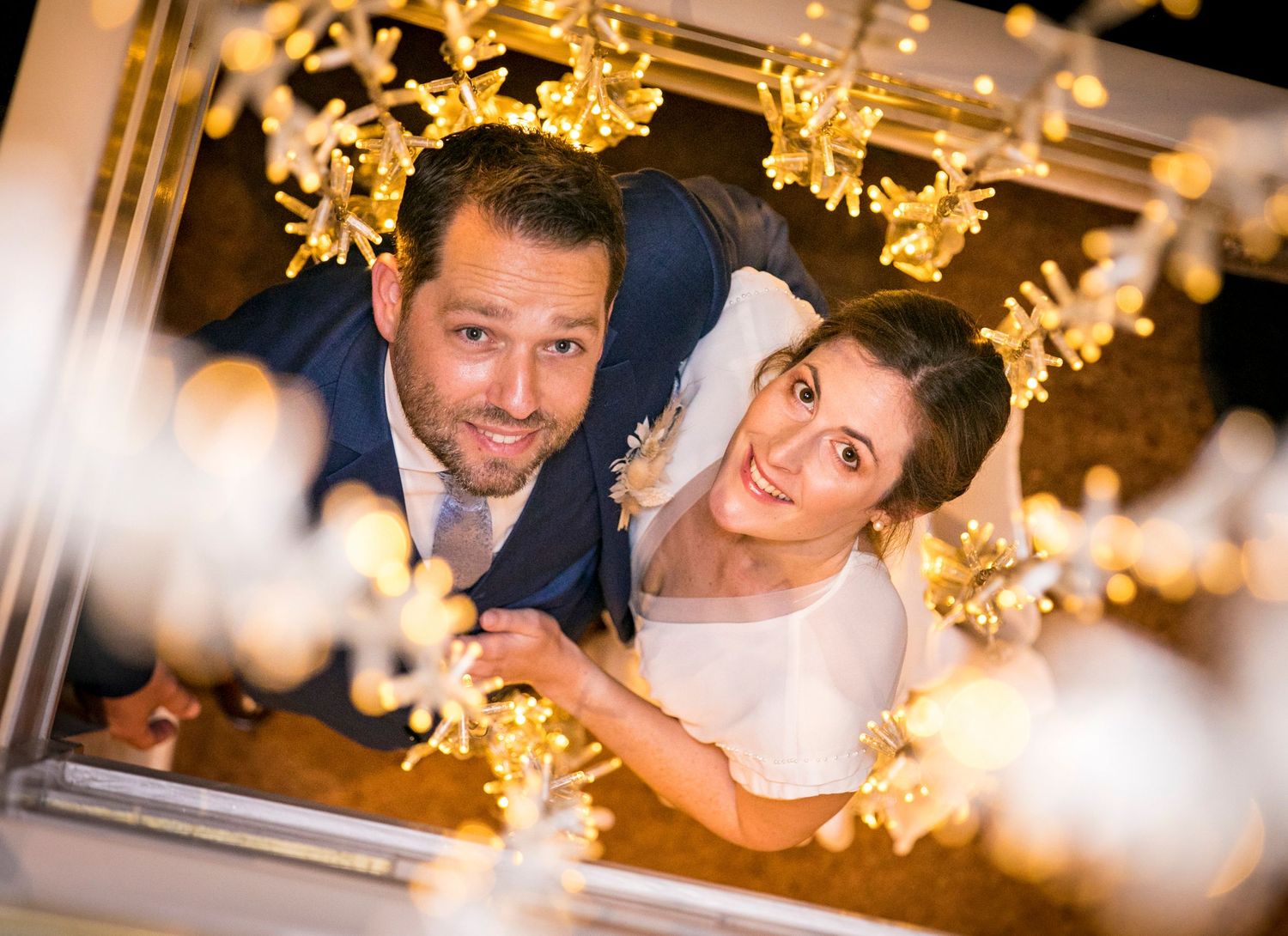 Wedding celebration with golden decorative lights creating a warm and festive atmosphere.
