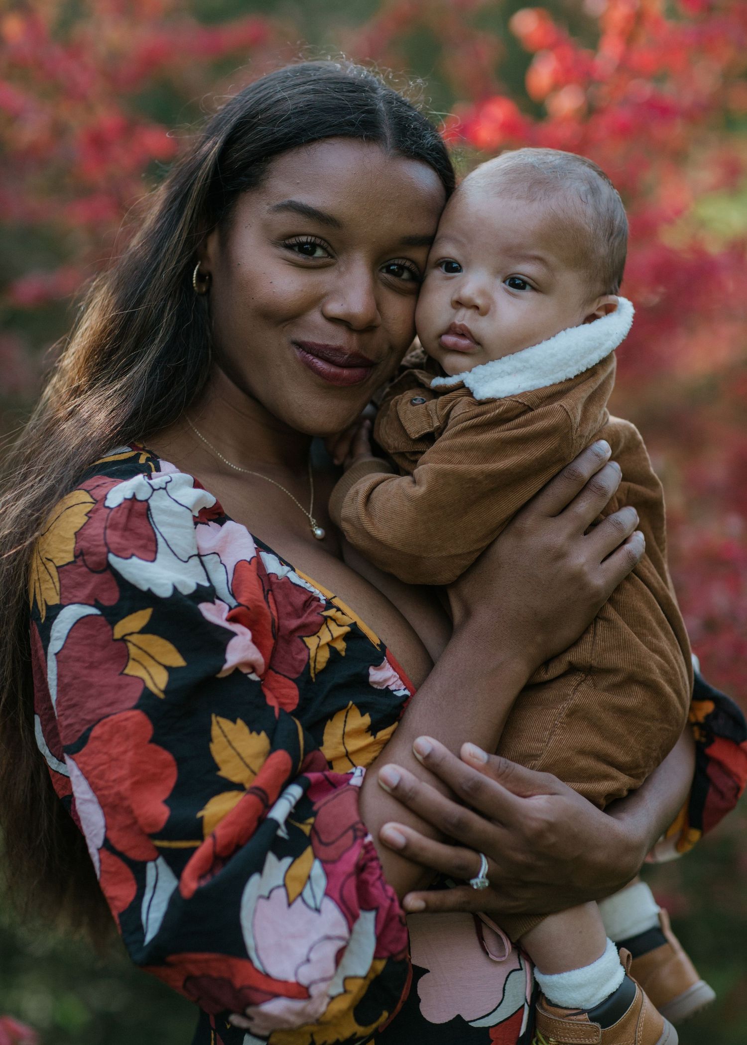 Mother and baby immersed in the beauty of vibrant fall colours near Ottawa, ON.
