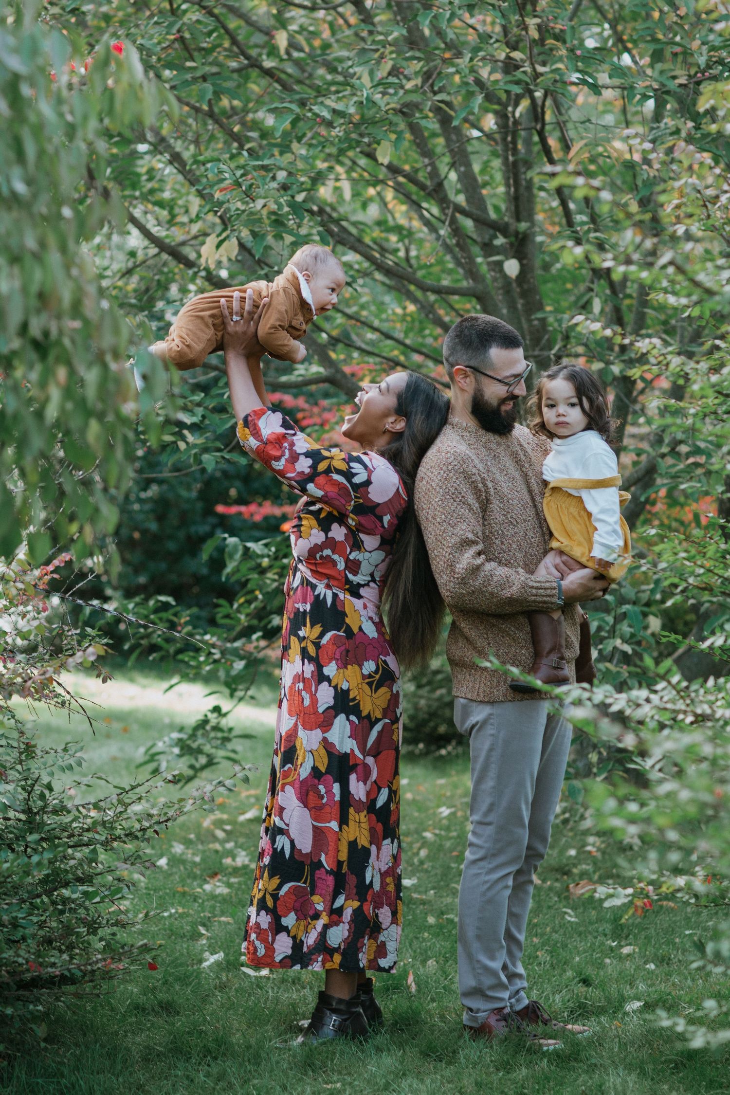Joyful family immersed in the beauty of vibrant fall colours, having fun and laughing, near Ottawa, ON.