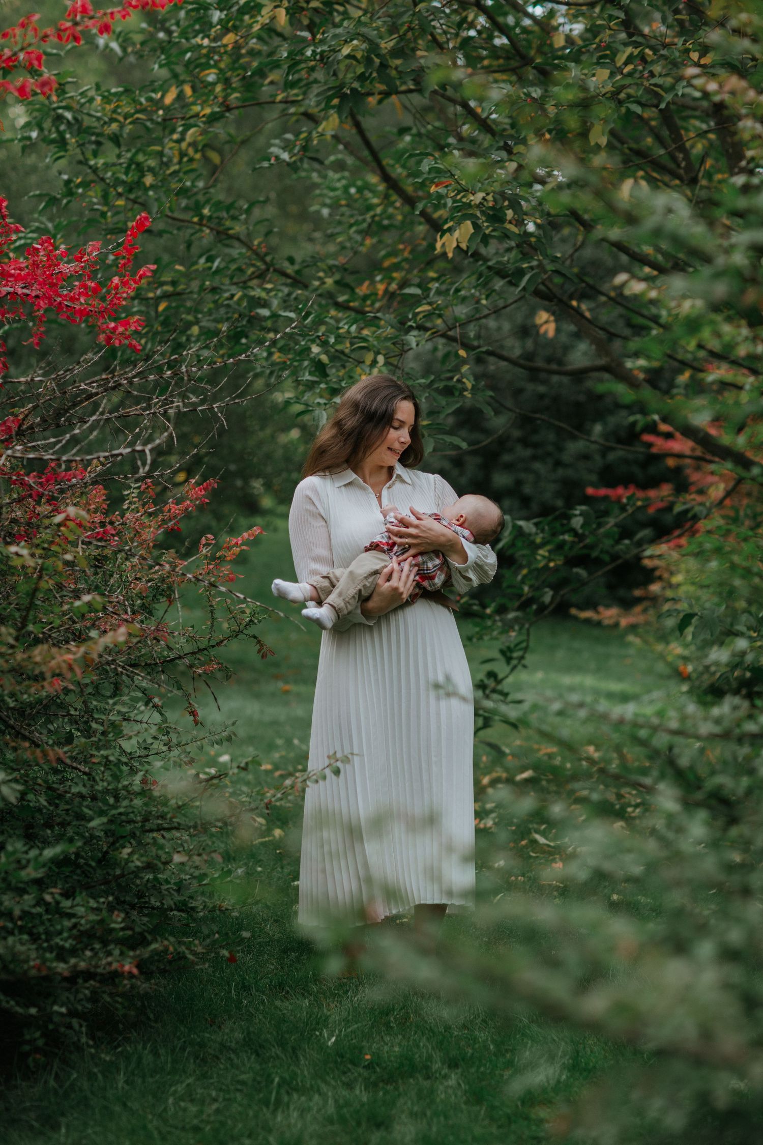 Mother and baby immersed in the beauty of vibrant fall colours near Ottawa, ON.