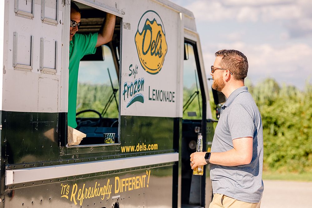 Food truck vendor opens service window on summer day.