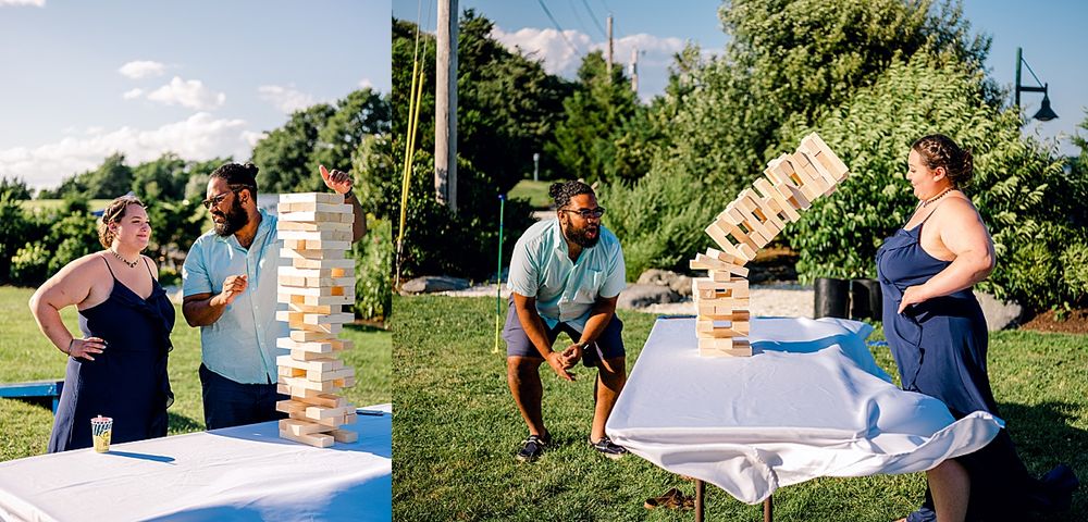 Wedding guests playing giant Jenga game outdoors on sunny day.