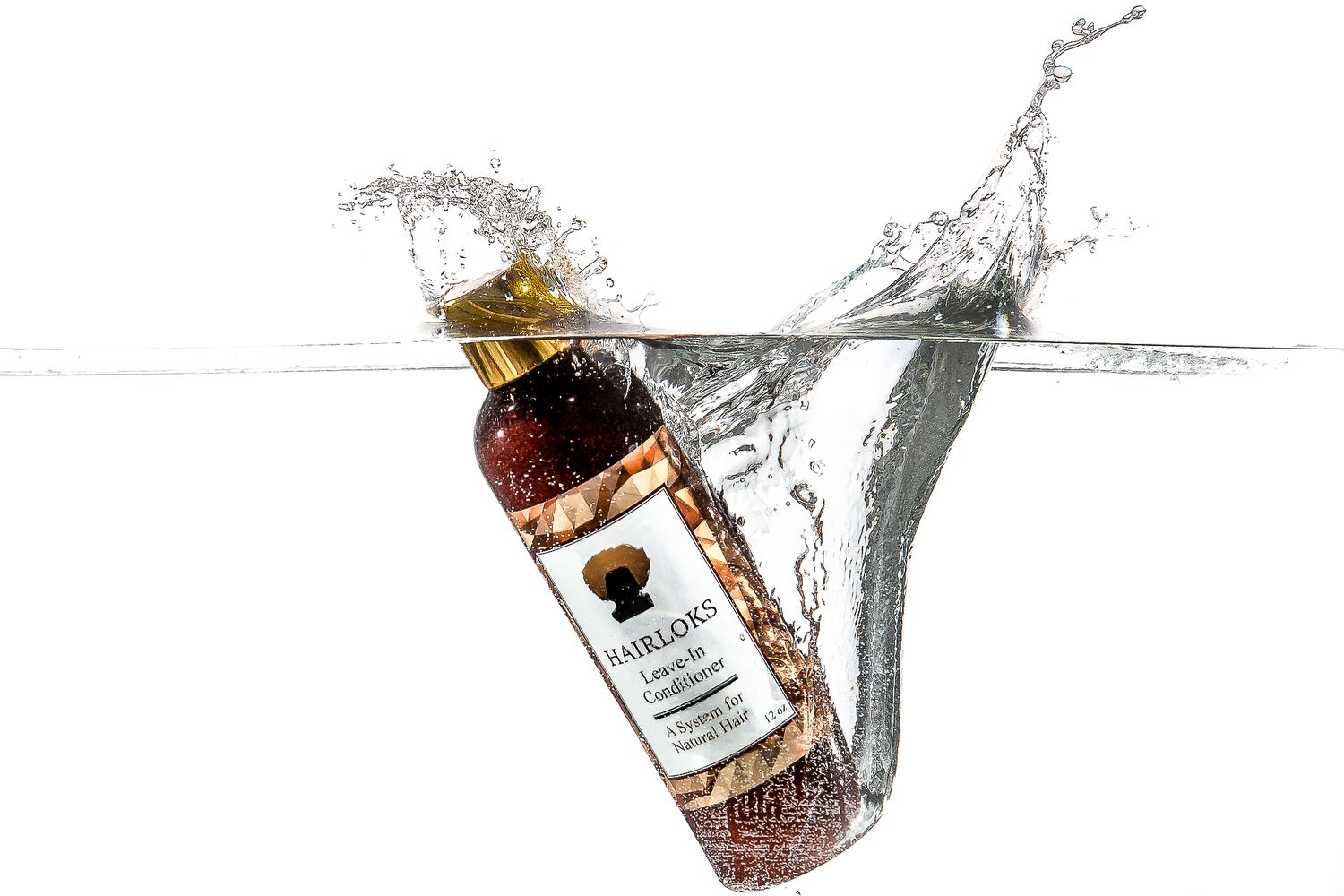 Splash photography of a whiskey bottle falling into clear water with dynamic splashes.