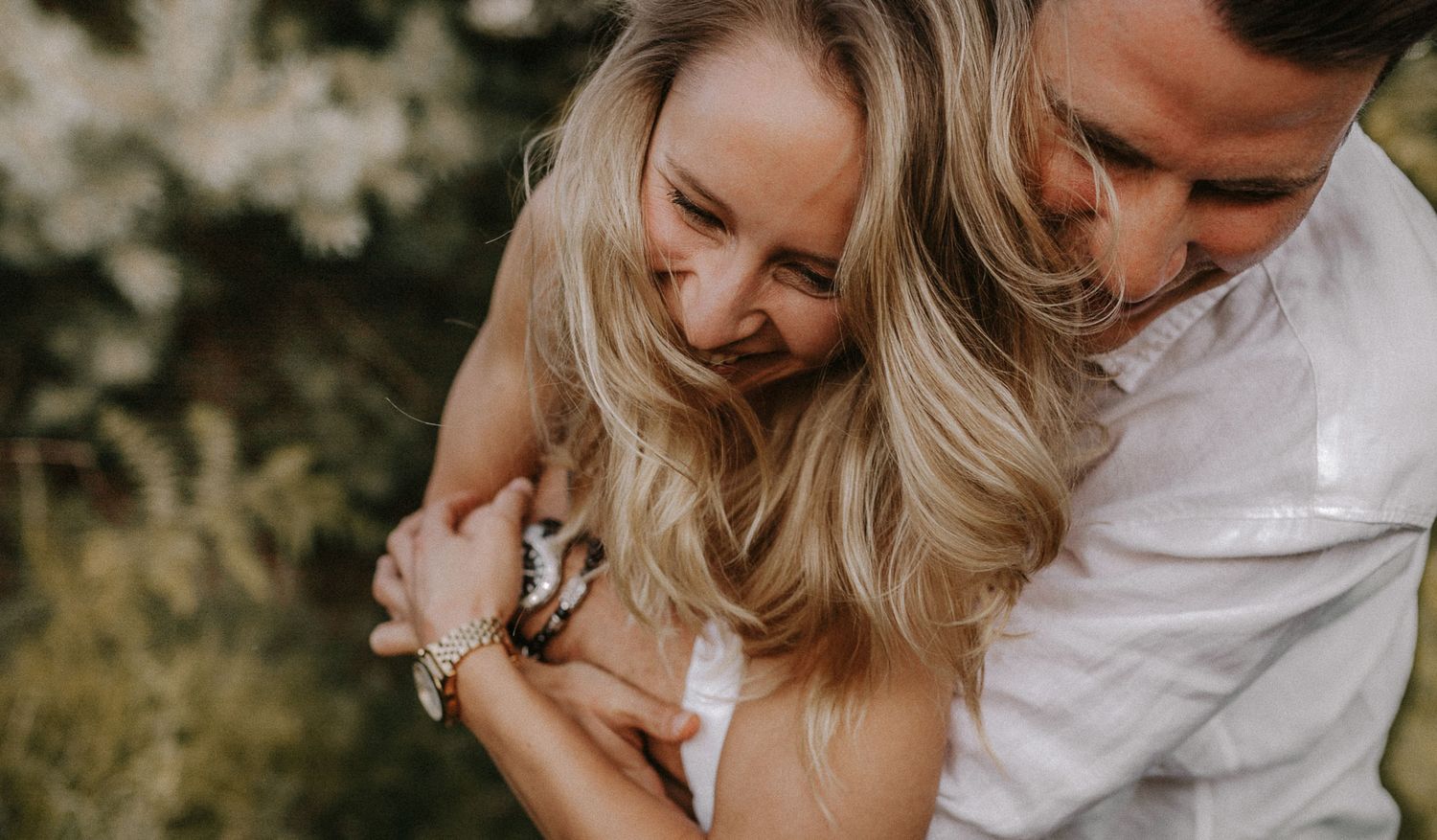 A candid moment of laughter and embrace captured in warm natural lighting.