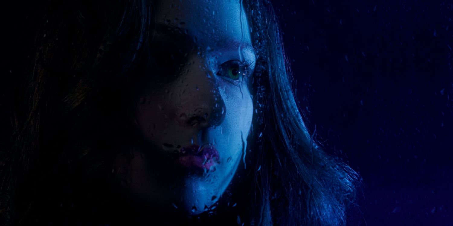 girl looking through rainy window