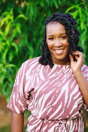 black female poses in front of trees