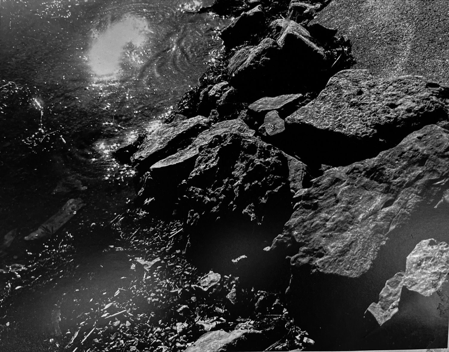 Black-and-white film photograph of rocks and water