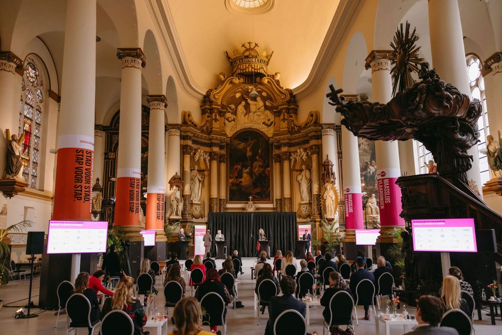 Grand church interior with baroque altar, classical columns and modern event seating setup.