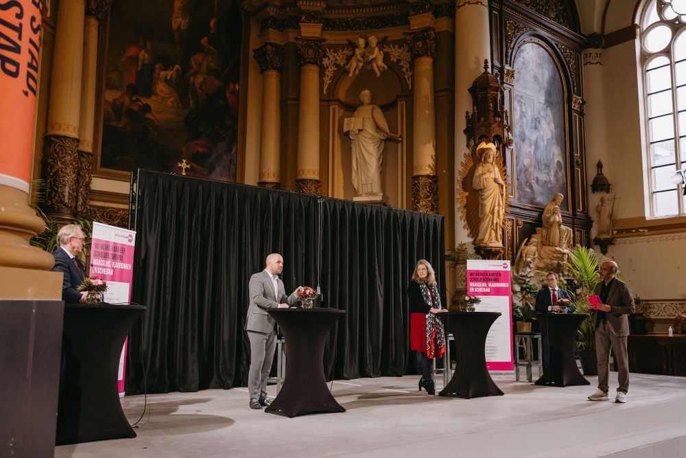 Event presentation taking place on stage in historic church interior with ornate baroque details.