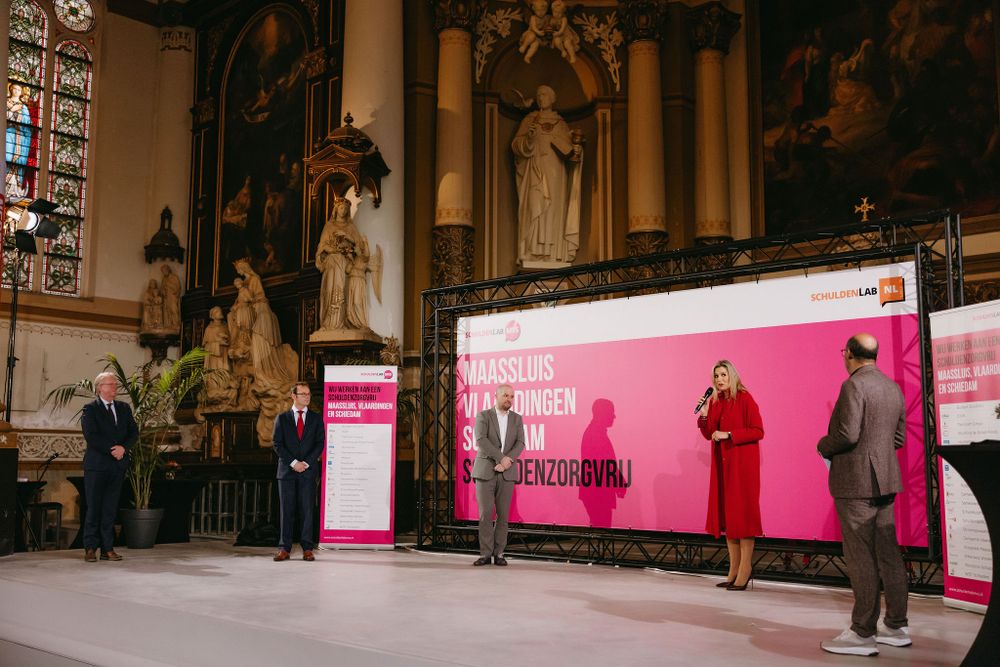 Stage performance with pink backdrop set against ornate church interior architecture.