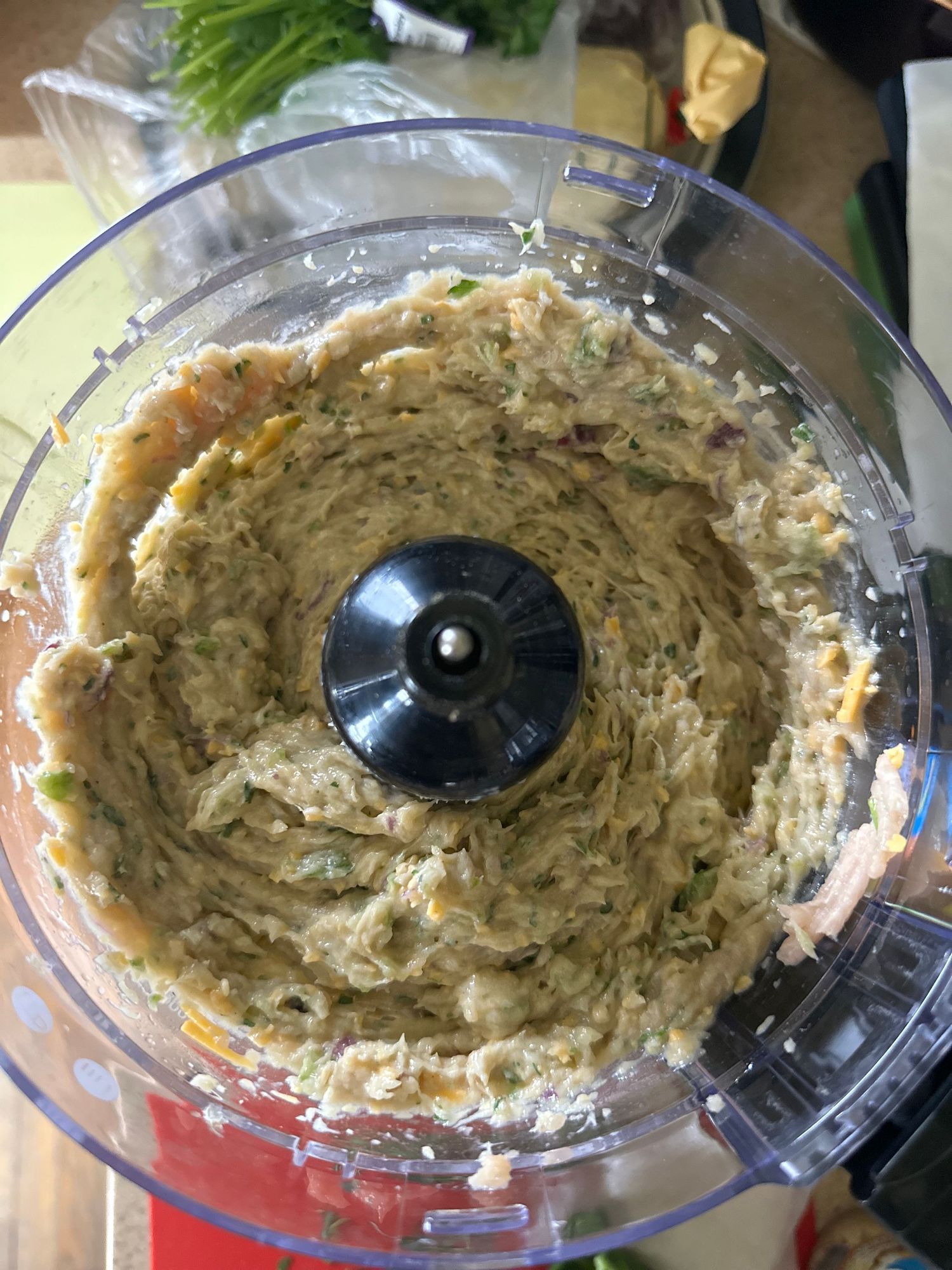 Creamy mixture being blended in a food processor bowl.