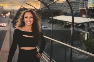 Urban sunset portrait on bridge wearing black crop top outfit.