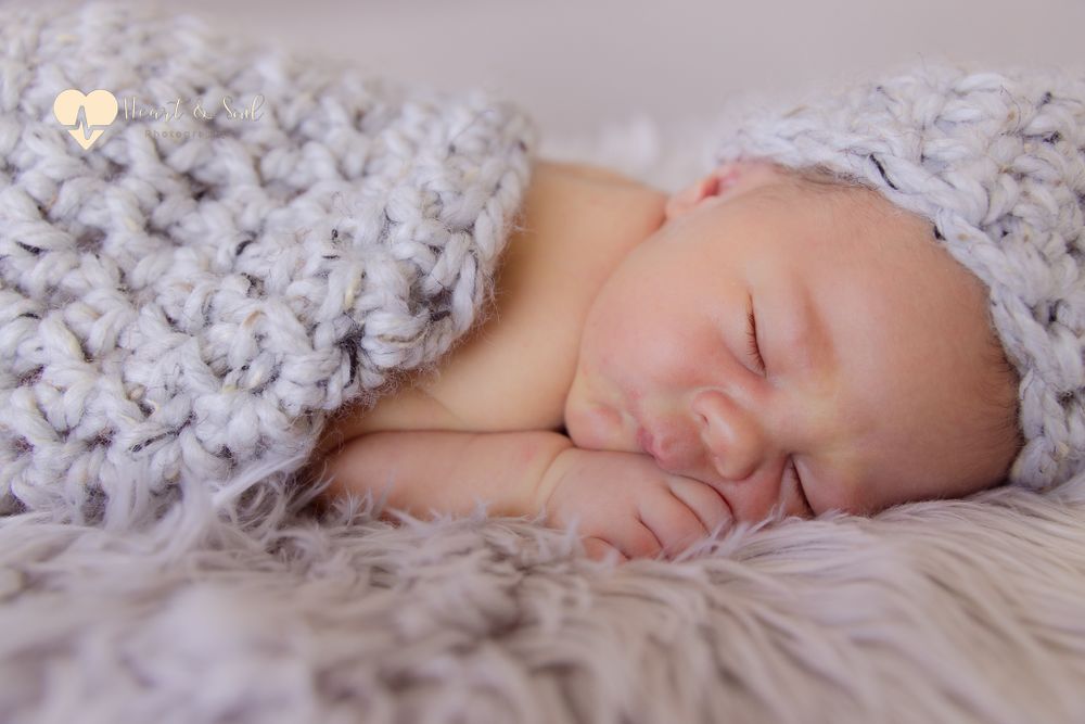 sleeping baby wrapped in grey blankets