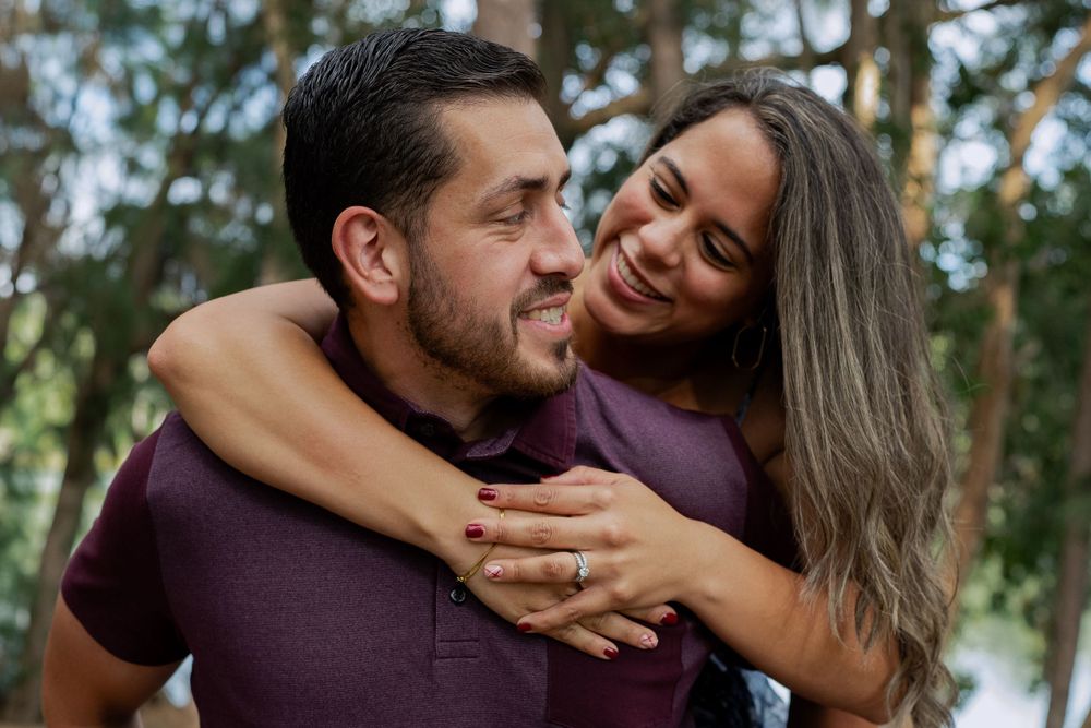 husband giving wife a piggyback ride at a park