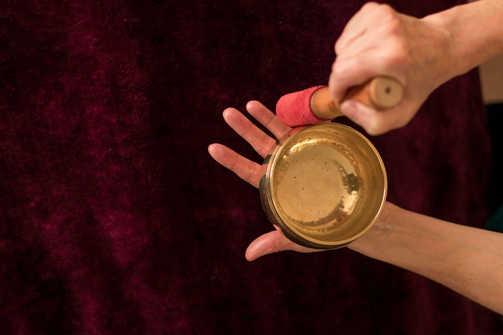Overhead photo of  Massage therapist using a zen signing bowl during her brand photography session.