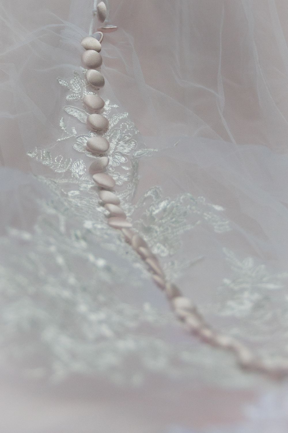 Close up photo of button details against lace on a wedding dress from a lifestyle photoshoot.