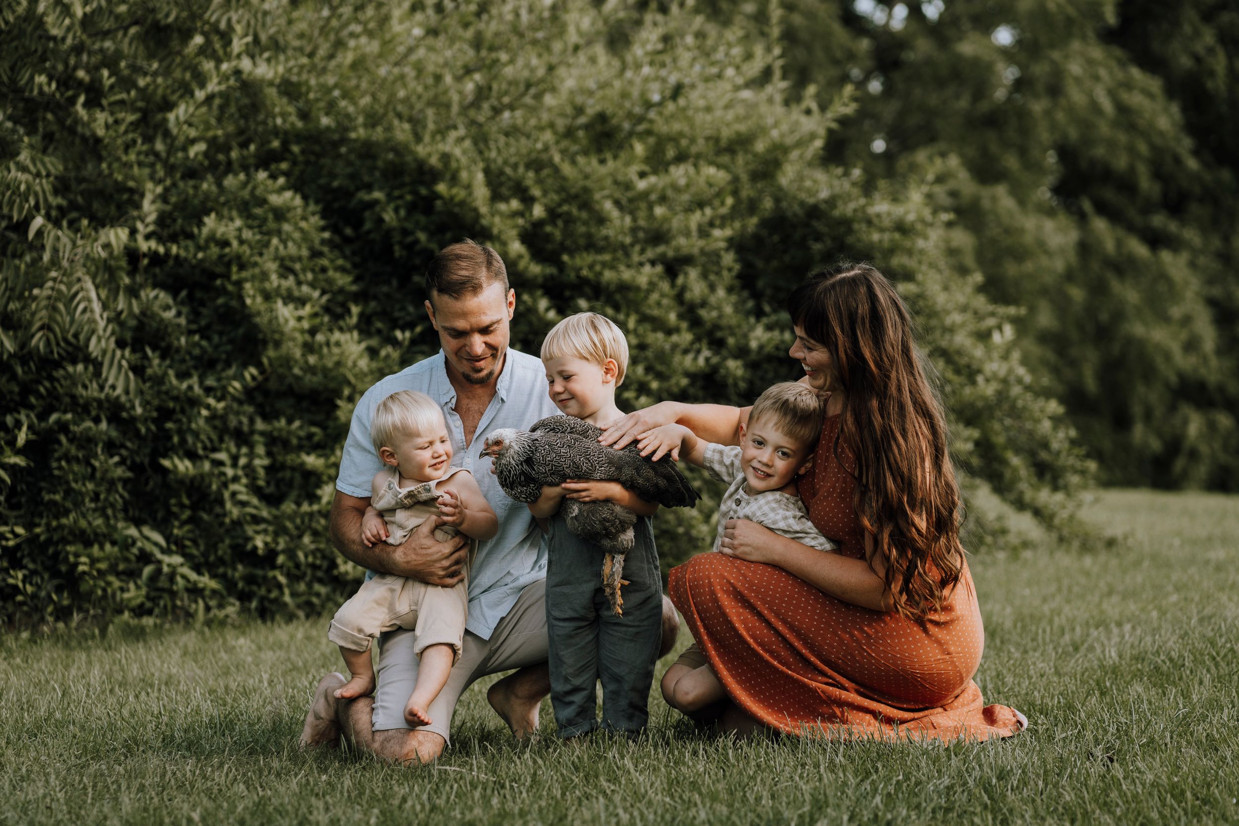 Family enjoying quality time together outdoors on a sunny day in a grassy field.