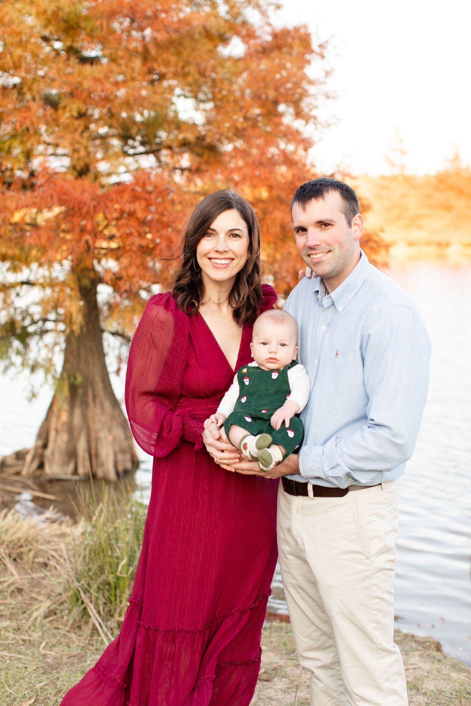 Outdoor family photo by water with cypress trees showing warm autumn colors.