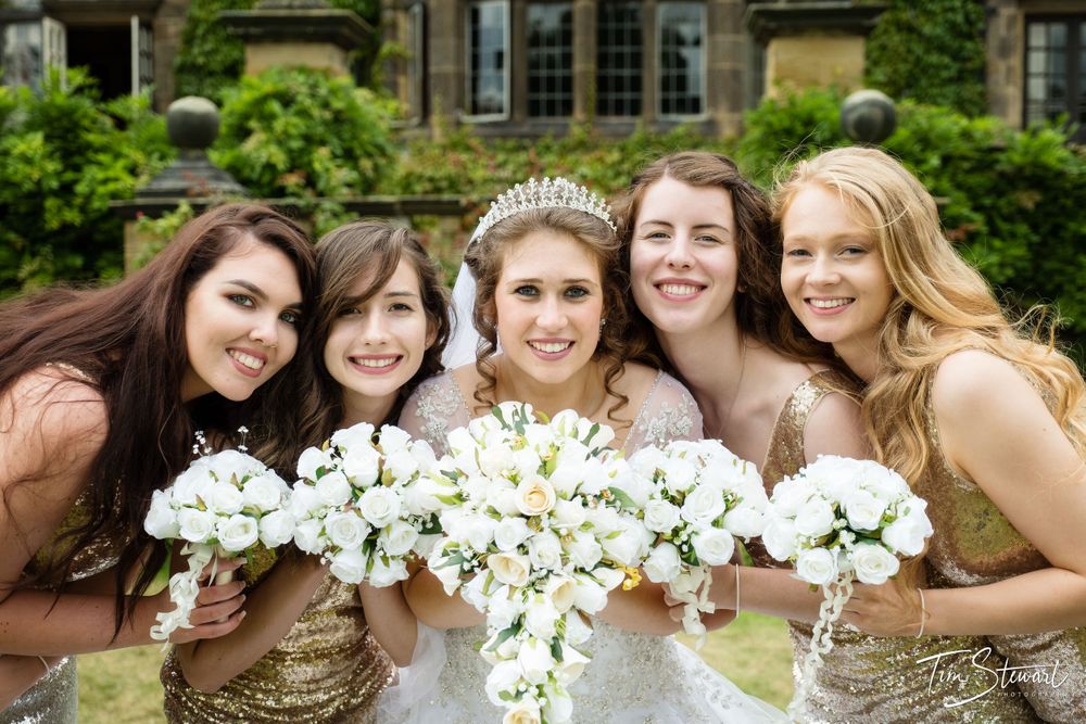 Bridesmaids with flowers outside Gisborough Hall, North Yorkshire.